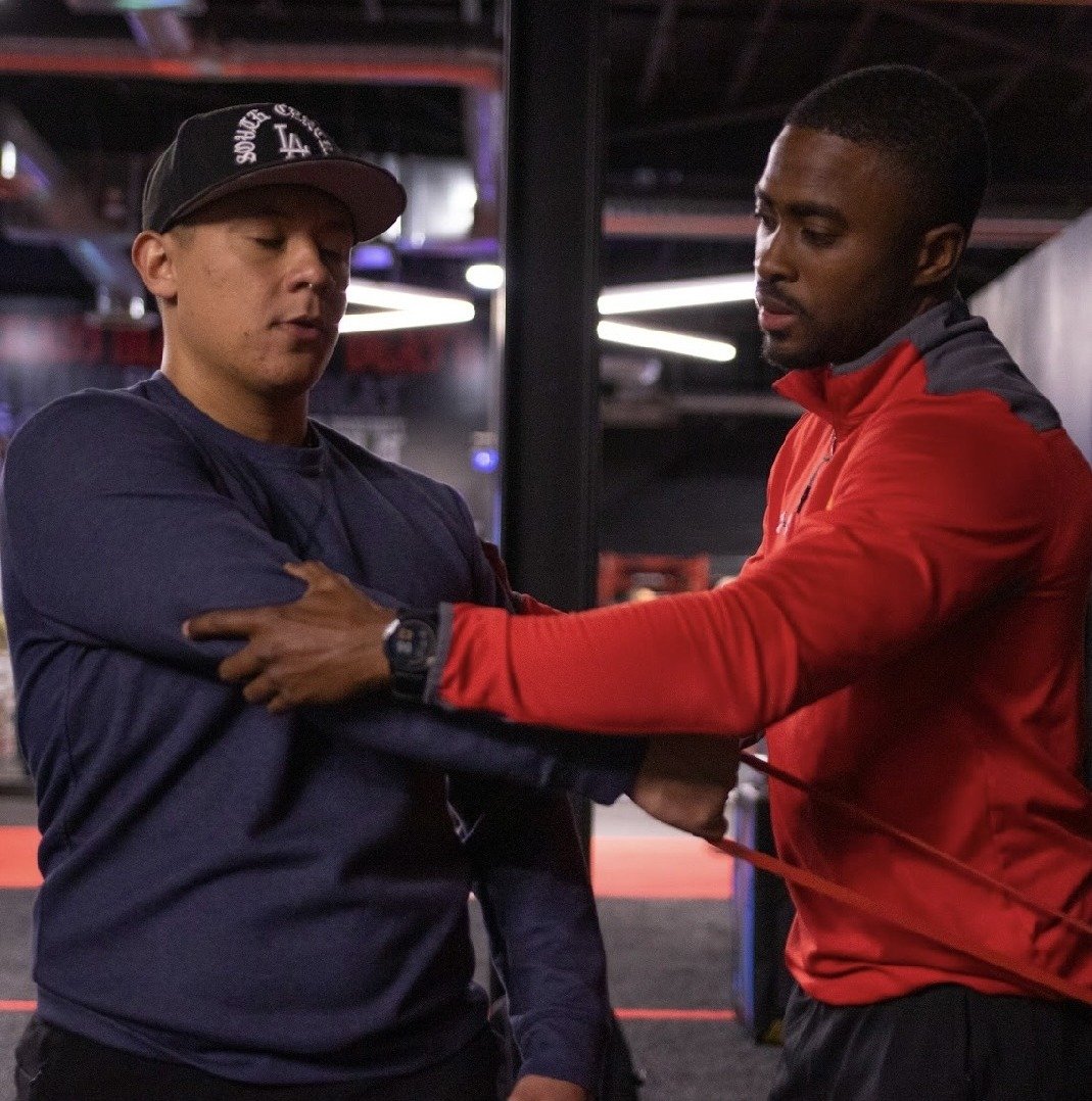 Andre Arthur coaching an athlete through a band-resisted assessment